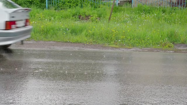 Summer rain. Raindrops on the asphalt. 4K
