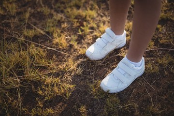 Feet of child standing on grass in boot camp
