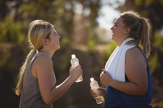 Friends interacting while having water after workout 