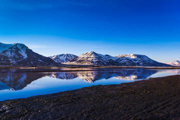landscape of the Arctic Ocean and reflection with blue sky and winter mountains with snow  ,...