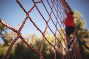 Boy climbing a net during obstacle course