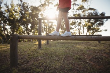 Low section of kid walking on obstacle during obstacle course