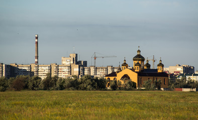 Fototapeta na wymiar Houses and cathedral on the outskirts of the city