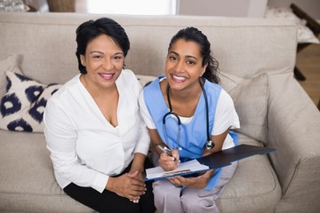 Patient sitting with doctor checking medical report