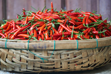 Fresh red chili peppers close up in a basket. Cooking ingredients.