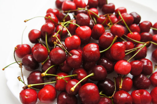 Red sweet cherry berries on white plate