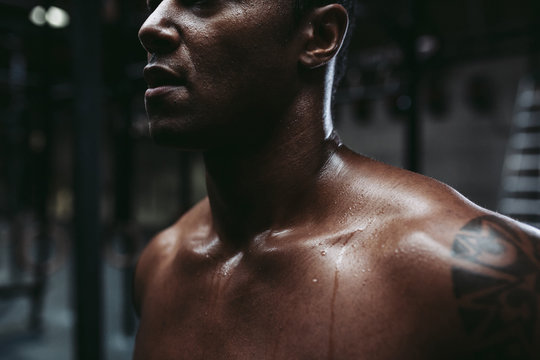 Young, fit black man recovering after training hard in fitness gym