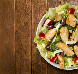 Fresh salad with chicken breast, arugula, olive and tomato. Healthy eating.Top view