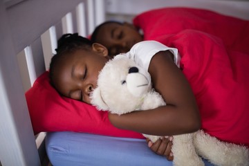 Obraz premium Siblings sleeping on bed at home