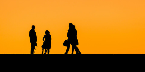 Fototapeta na wymiar Tourists waiting for the sundown. Near the Maspalomas Lighthouse in the south of Gran Canaria