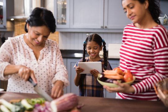 Happy multi-generation family preparing food in kitchen