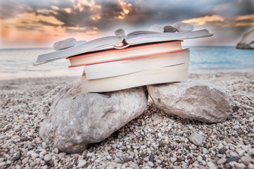 Reading open book at beach near the sea during summer vacation