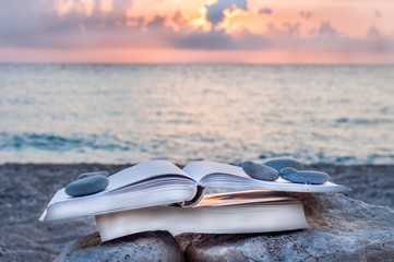 Reading open book at beach near the sea during summer vacation