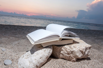 Fototapeta na wymiar Book at beach near the sea during summer vacation and holiday