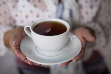 Mid section of woman holding tea cup