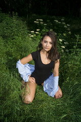 Fit young girl in bodysuit posing in a grass field