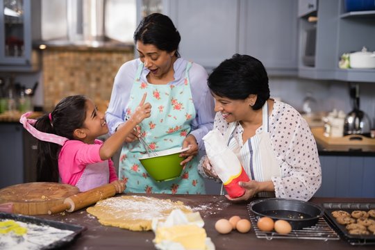 Happy multi-generation family preparing food