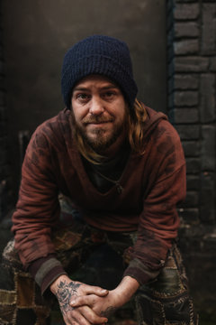 Portrait of young homeless man looking at camera with hopeful eyes