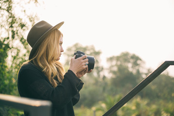 Blonde young woman taking photo of nature