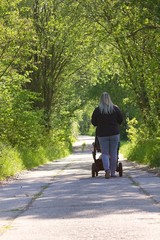 Mommy autumn walk with stroller in nature.