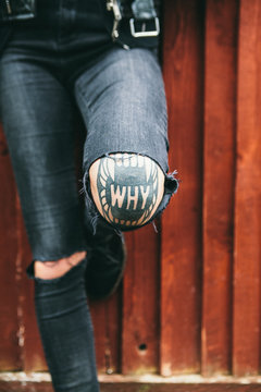 Womans tattoo on her knee spelling 'why'