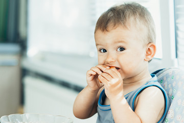 The child greedily eating the sausage