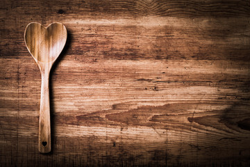 Kochen mit Herz -  Holzlöffel in Herzform auf Holz - Hintergrund