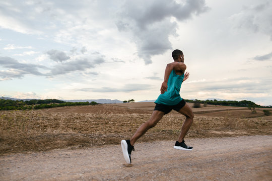 Runner training on a field path in autumn