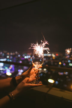 Woman's hands holding a sparkler glass