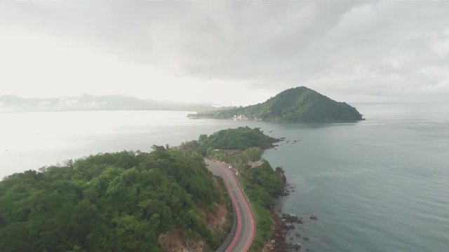 : Aerial view from drone of coastal road with bike lane to Nang Phaya Hill Scenic Point in Chanthaburi, Thailand