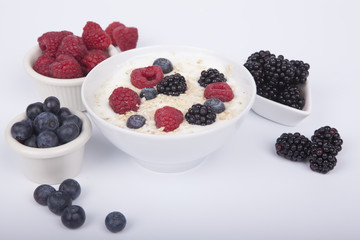 bowl of white yogurt with berries and oat flakes isolated