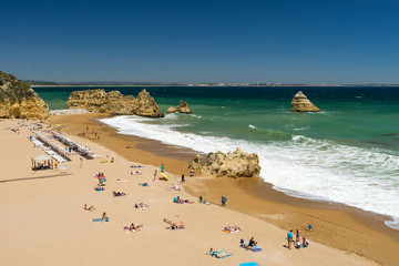 Very beautiful portugese beach with rocks, aquamarine sea and dark yellow sand