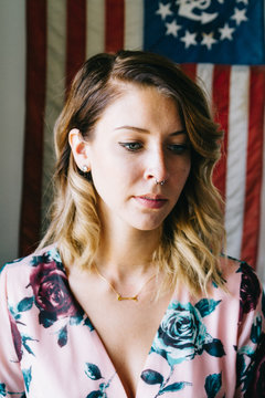 portrait of young female laughing in front of american flag 