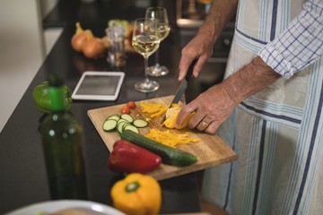 Mid section on man cutting bell pepper in kitchen