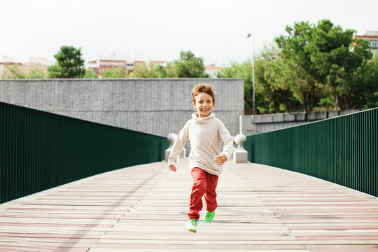 Smiling little boy running in the park
