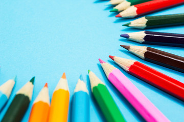 Bright abstract background of multi-colored pencils in the shape of a circle, top view. Space for text.