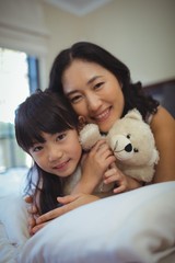 Mother and daughter relaxing on bed in bed room