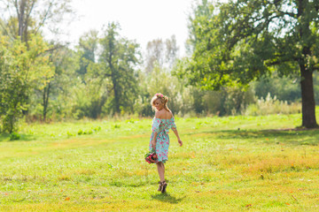 Portrait of the young beautiful romantic woman in dress outdoors