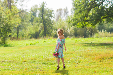 Portrait of the young beautiful romantic woman in dress outdoors