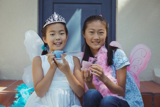 Siblings in fairy costume having a tea party - Powered by Adobe