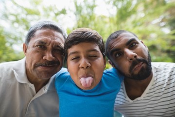 Portrait of happy multi-generation family making faces at park