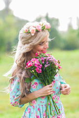 outdoor portrait of a beautiful blonde woman. attractive happy girl in a field with bouquet of flowers.