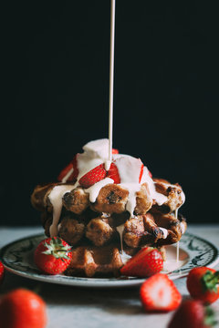 Strawberry waffle stack, with cream being poured over it