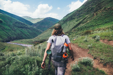 hiker outdoorsman hiking on a mountain path in the mountains overlooking a valley
