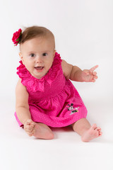 Baby girl in pink dress on white background