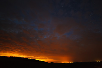 Clouds at night against the background of bright stars in the sky after sunset.