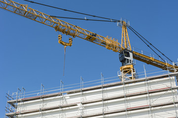 The high crane behind the future with a scaffold.