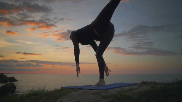 Peaceful girl doing yoga meditate virabhasana sunrise coast slow motion