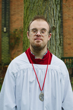 A man with Down's Syndrome wearing altar serving robes