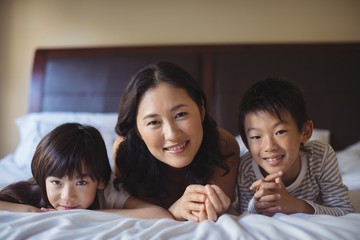 Mother with daughter and son relaxing on bed in bed room